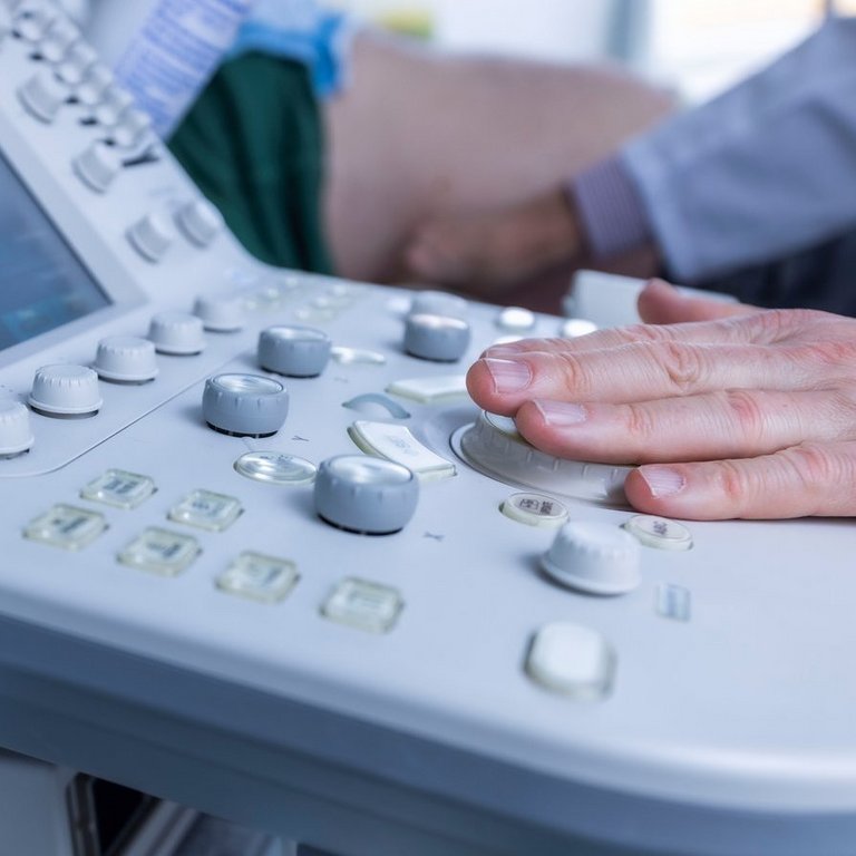 Nahaufnahme eines modernen Ultraschallgeräts, das von einem Arzt im AKH Celle während einer Untersuchung bedient wird.