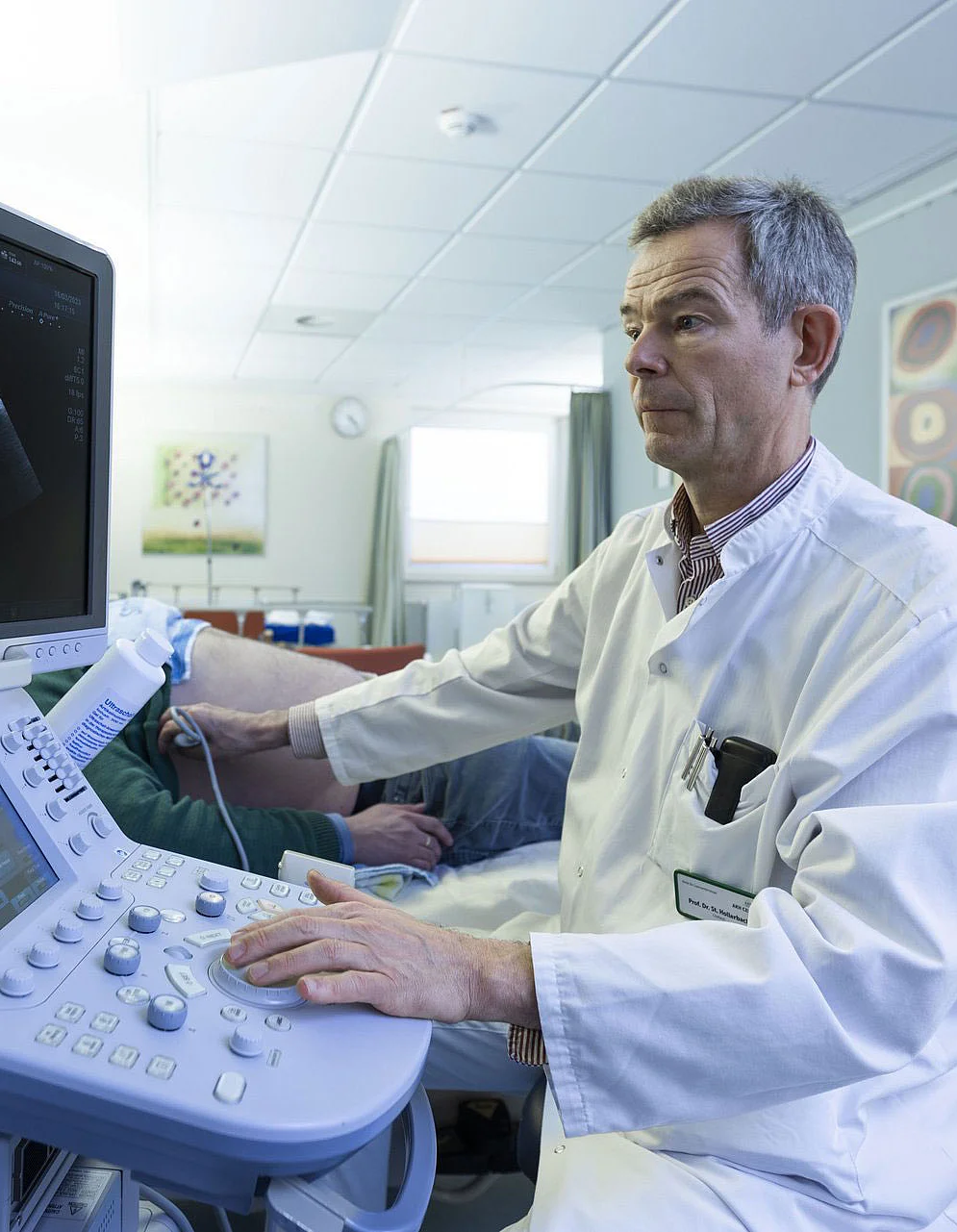 Ein Arzt macht einen Ultraschall an einem männlichen Patienten.