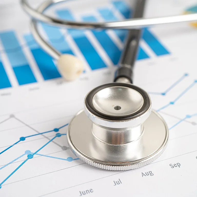 Ein Stethoskop liegt auf medizinischen Statistiken und Diagrammen – Symbol für die Verbindung von Medizin und Datenanalyse.
