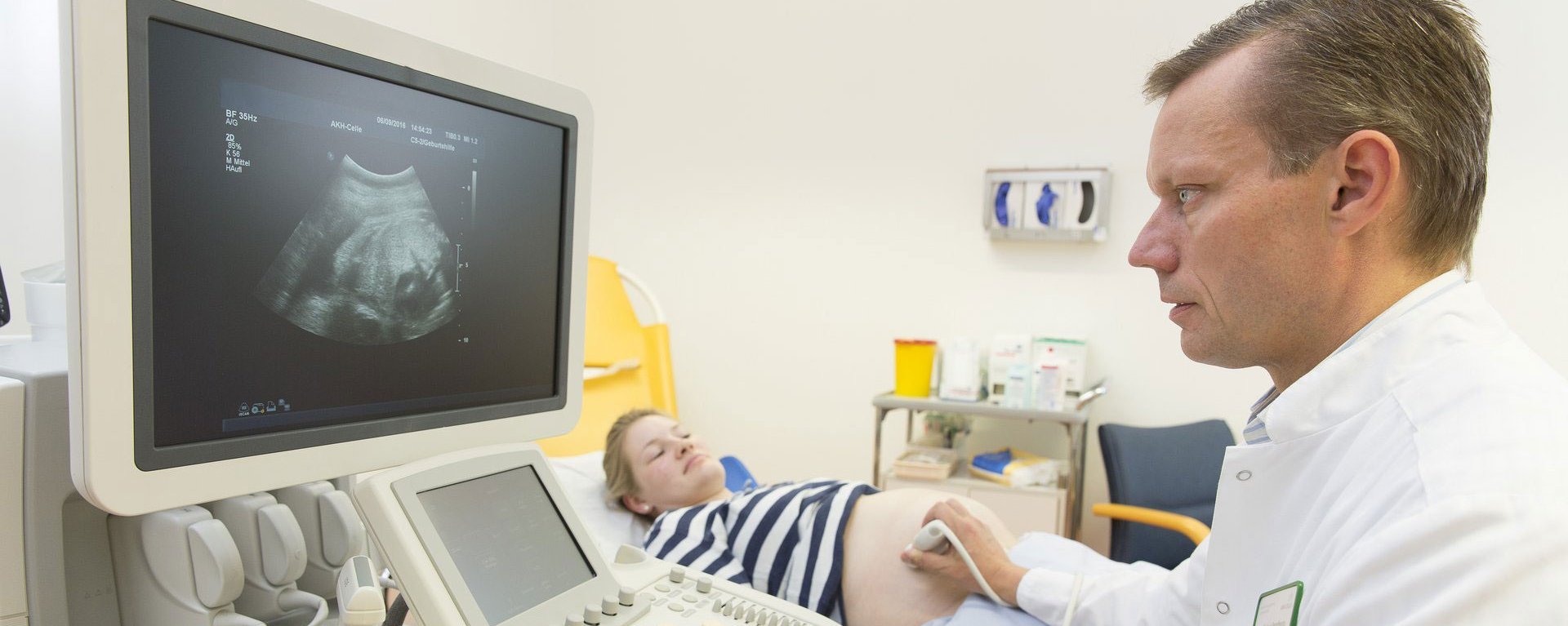 Arzt führt eine Ultraschalluntersuchung bei einer schwangeren Patientin durch.