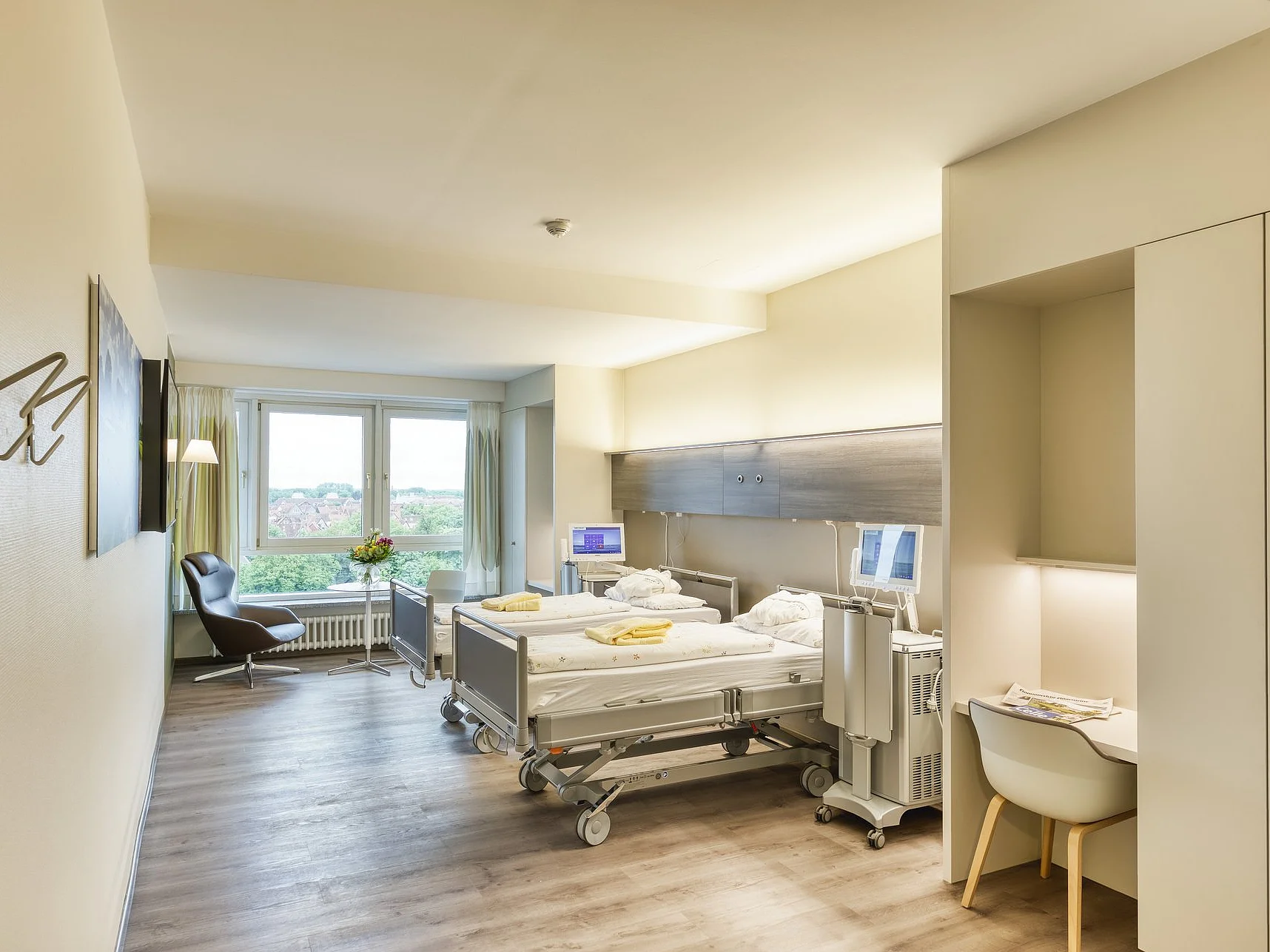 Helles, modern ausgestattetes Patientenzimmer im AKH Celle mit Pflegebett, medizinischer Ausstattung und Blick ins Freie.