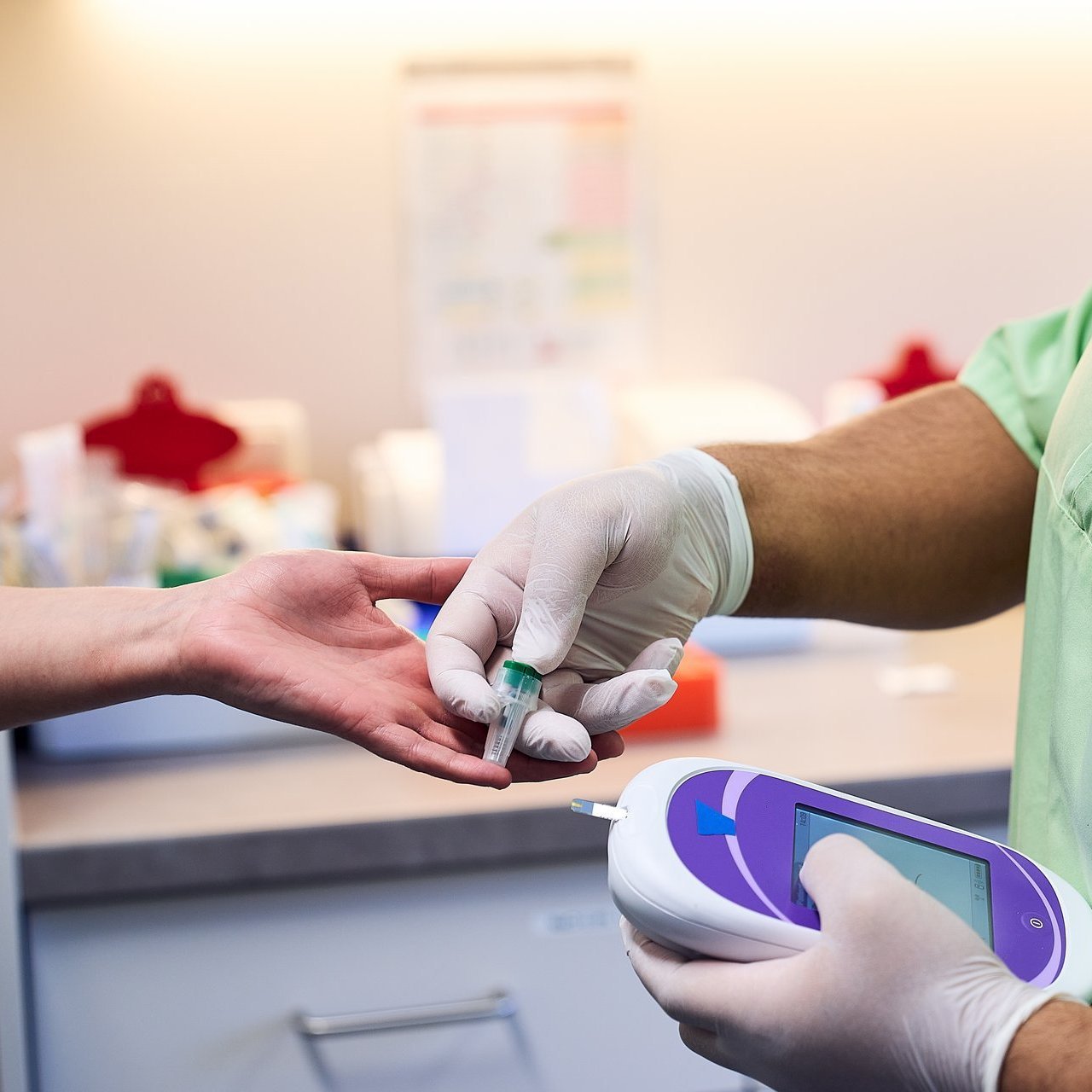 Medizinisches Personal misst den Blutzuckerwert einer Patientin per Fingerstich.