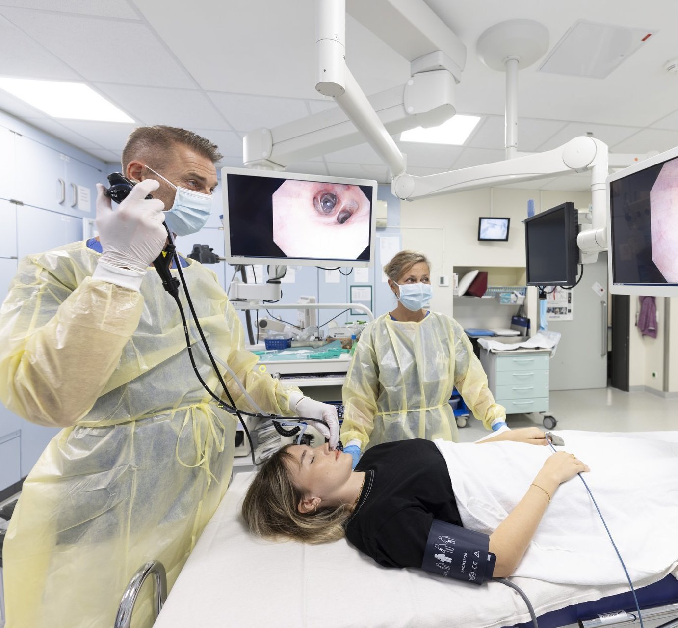 Ärzteteam im AKH Celle führt eine Bronchoskopie durch, während die Atemwege der Patientin in Echtzeit auf Monitoren sichtbar sind.