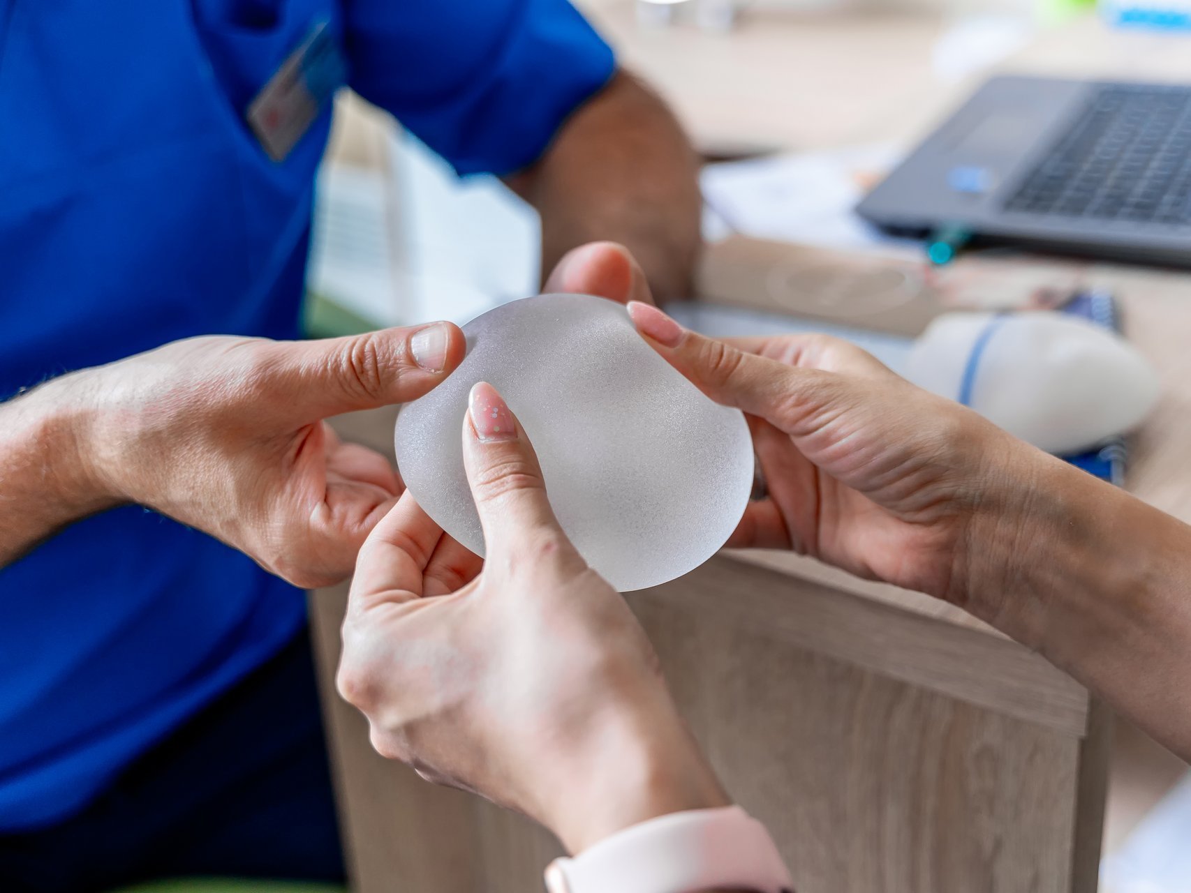 Physiotherapeut führt Mobilisationsübung an bandagiertem Knie eines männlichen Patienten durch