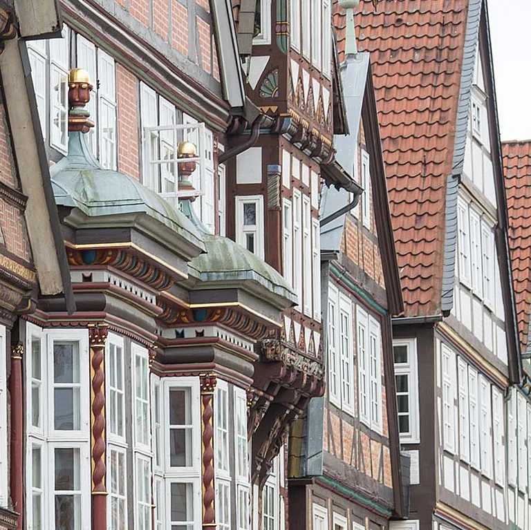 Reihe historischer Fachwerkhäuser in der Altstadt von Celle. Die detailreich verzierten Fassaden und roten Ziegeldächer spiegeln den traditionellen norddeutschen Baustil wider.