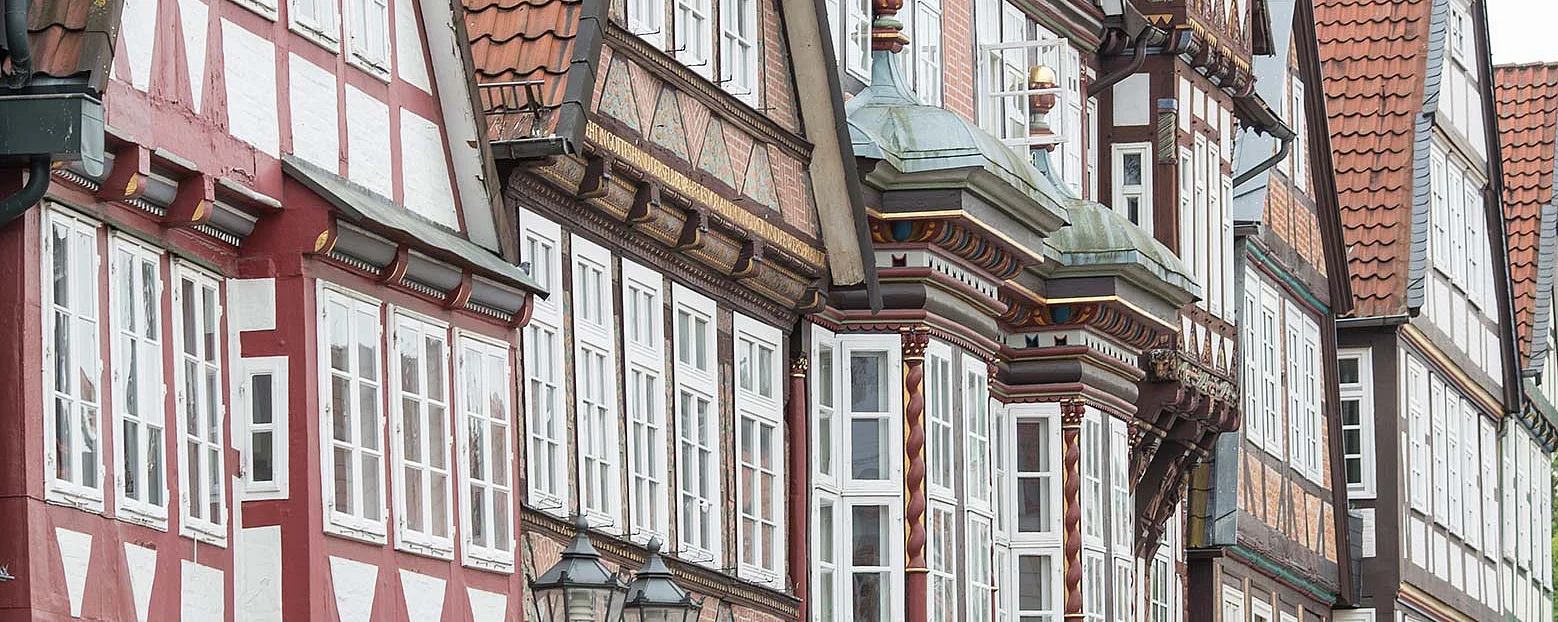 Reihe historischer Fachwerkhäuser in der Altstadt von Celle. Die detailreich verzierten Fassaden und roten Ziegeldächer spiegeln den traditionellen norddeutschen Baustil wider.