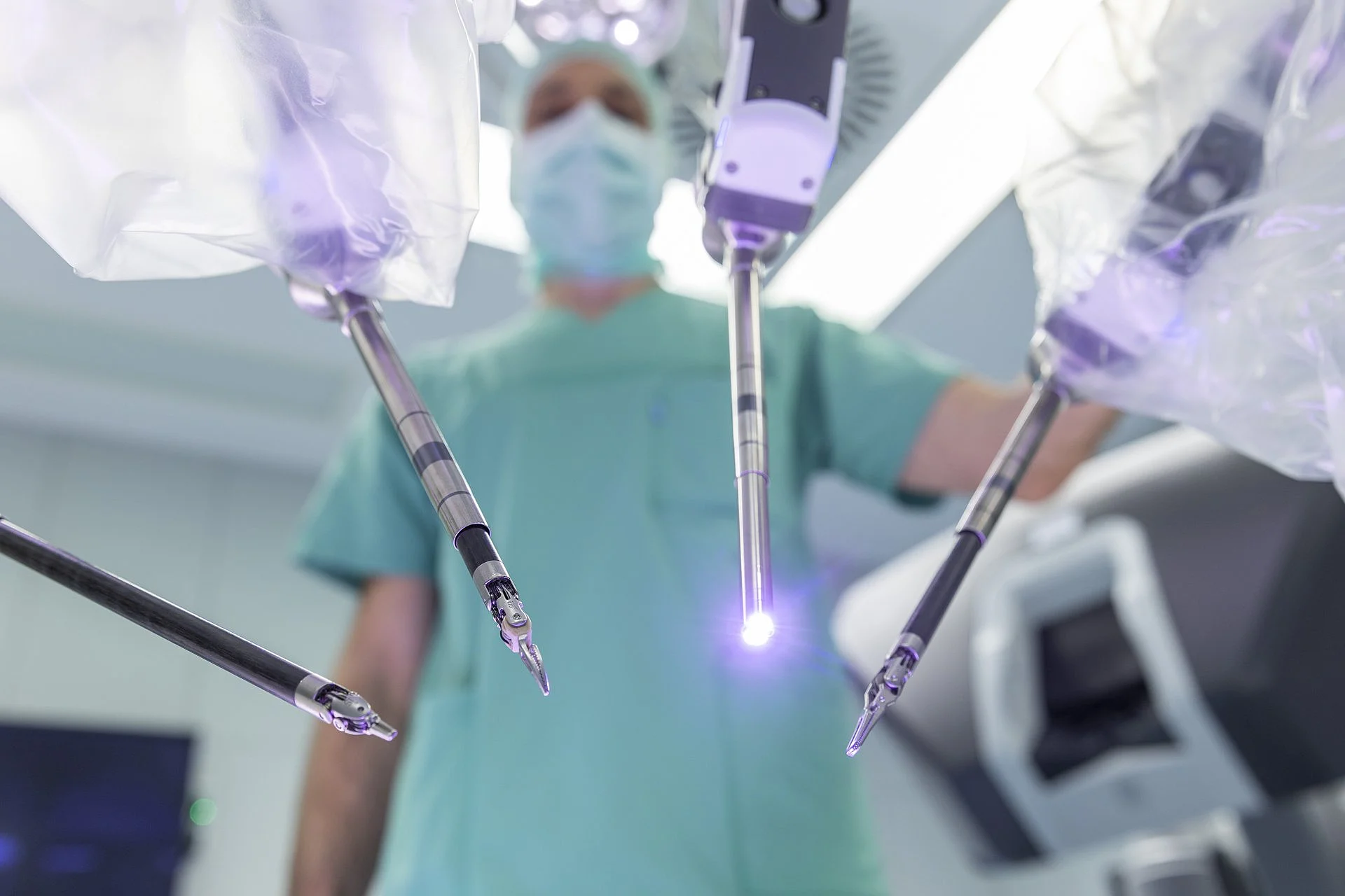 Chirurg bedient robotergestützte OP-Instrumente unter sterilen Bedingungen bei minimalinvasivem Eingriff.