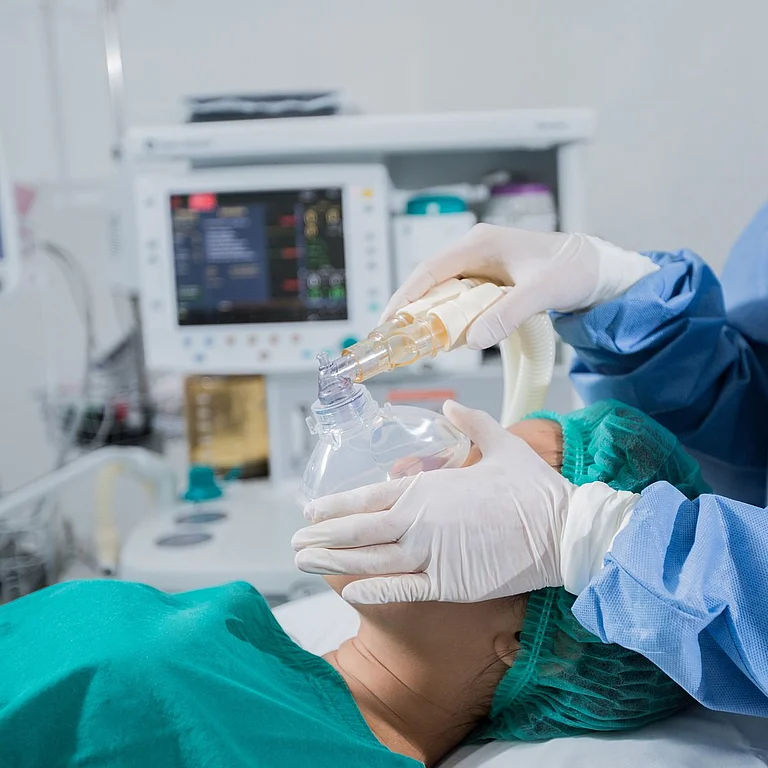 Anästhesist im OP des AKH Celle überwacht die Vitalfunktionen eines Patienten auf einem Monitor. Im Hintergrund ist medizinisches Equipment zu sehen.