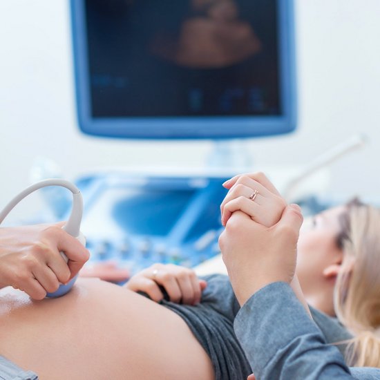 Mit einem Ultraschall wird der Bauch einer schwangeren Frau untersucht.